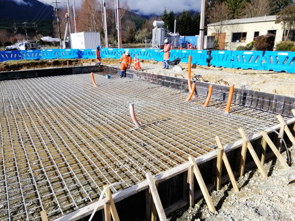 Three workers working on a job site with fiberglass rebar laid out