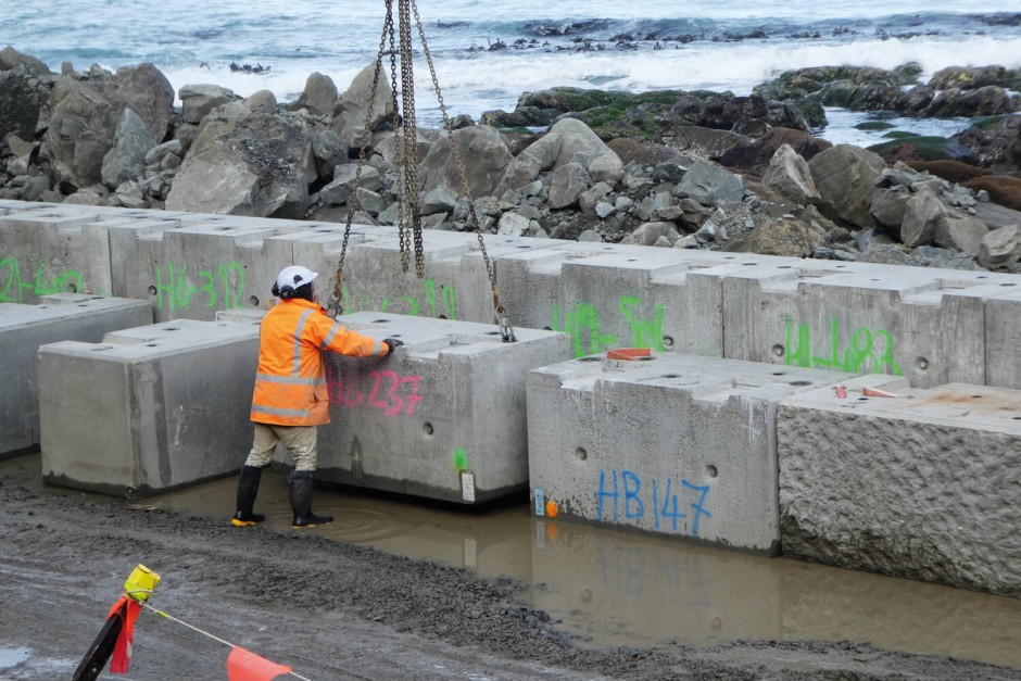 A construction worker standing in front of a concrete block