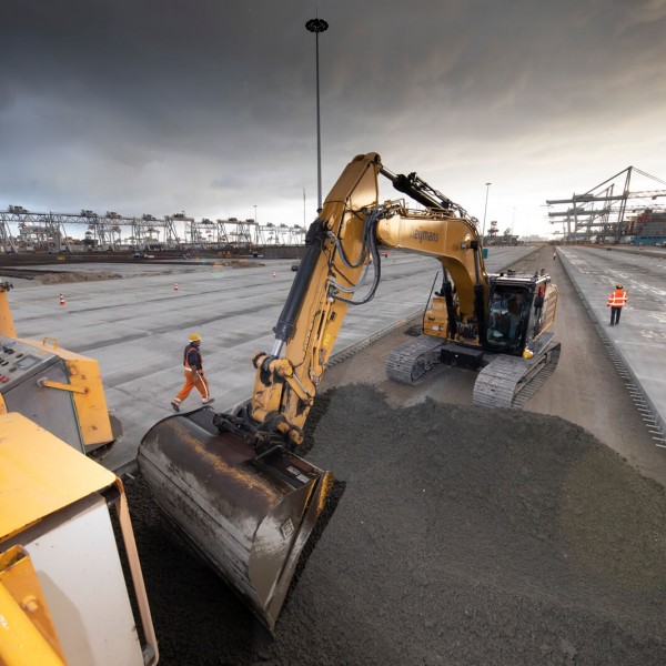 A large machine shovelling dirt on a dim job site