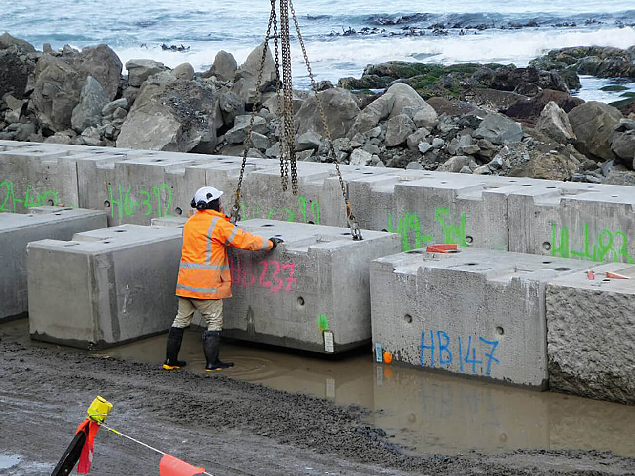 A worker standing over a block of concrete by the Grand Paris Express