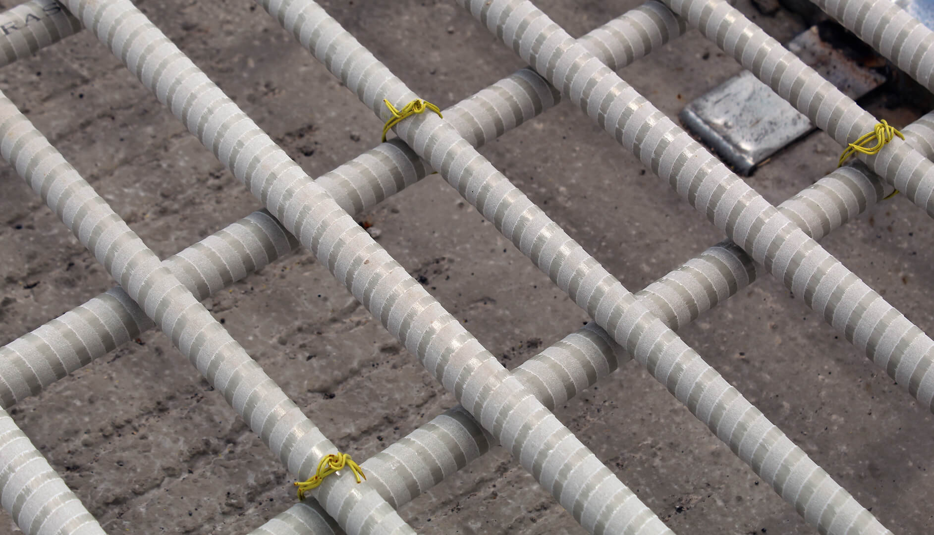 Grey fiberglass rebar tied down by yellow ties