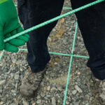 A worker holding a stick of Greenbar2X while standing in between high visibility bars