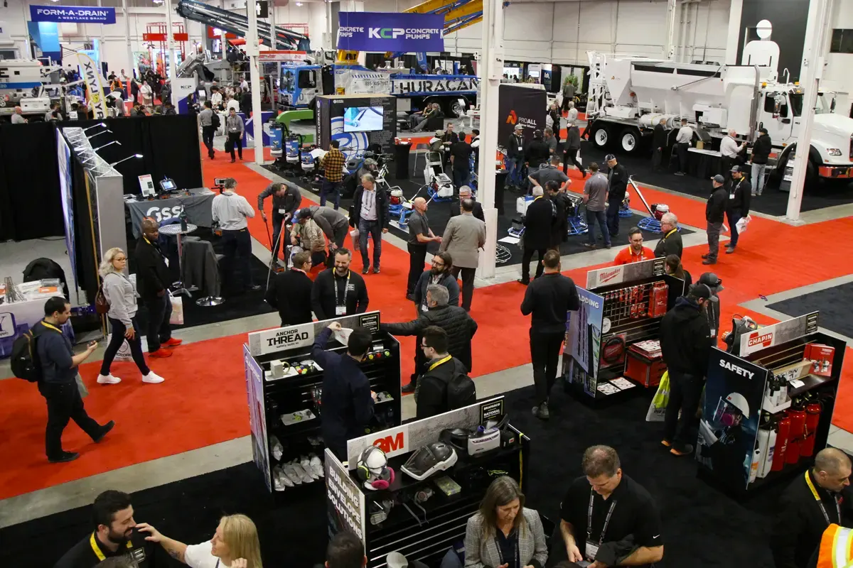 A lot of people conversing near booths at the Canadian Concrete Expo.