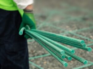A person holding multiple bars of Greenbar2X fiberglass rebar