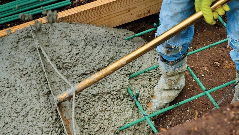 A man leveling poured concrete over Greenbar2X fiberglass rebar