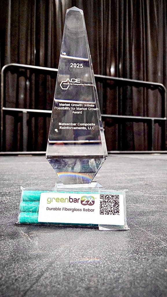 A plastic bag with three small bars of green fiberglass rebarin front of a trophy