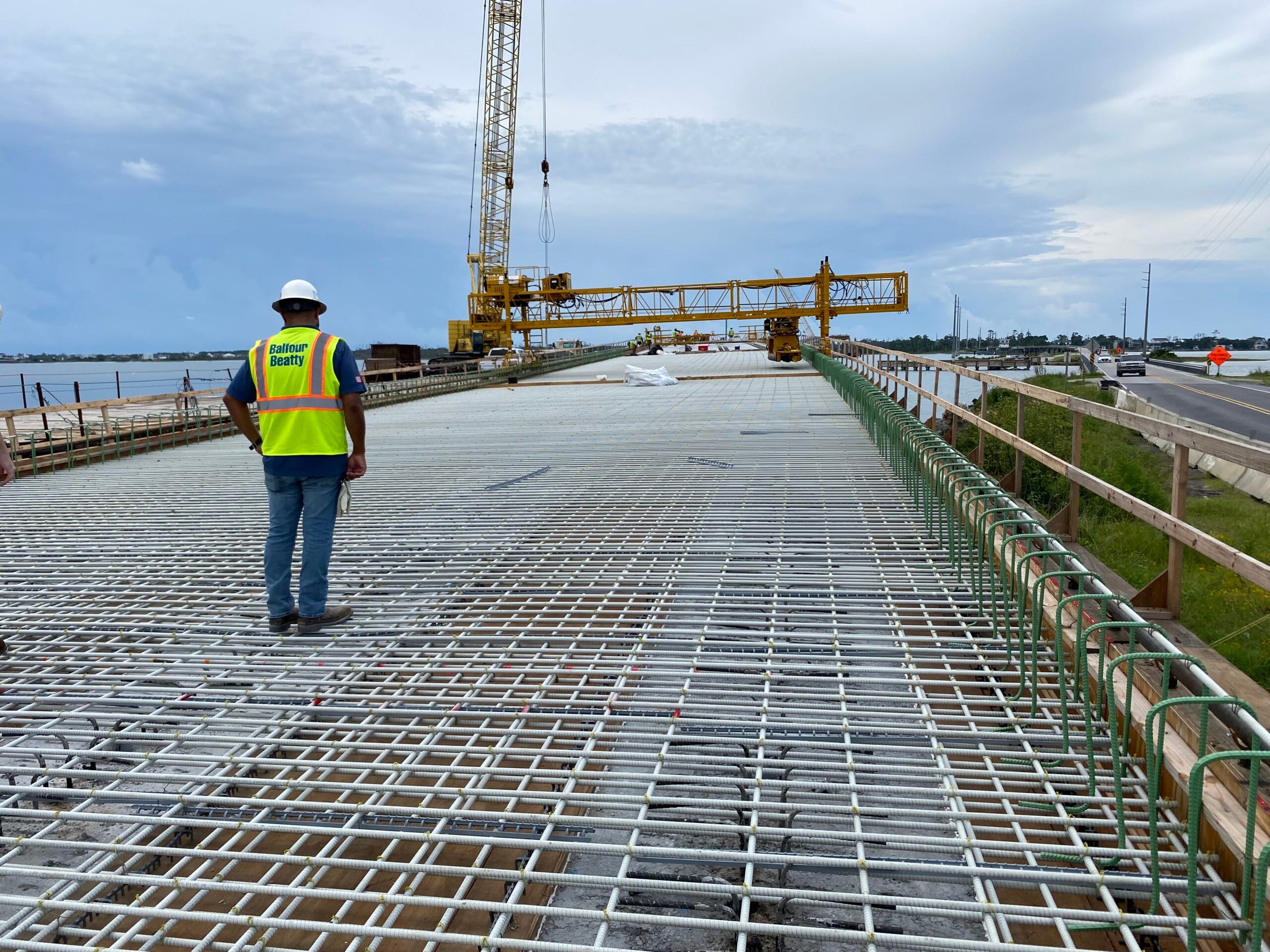 A construction worker standing on a bridge with installed fiberglass rebar