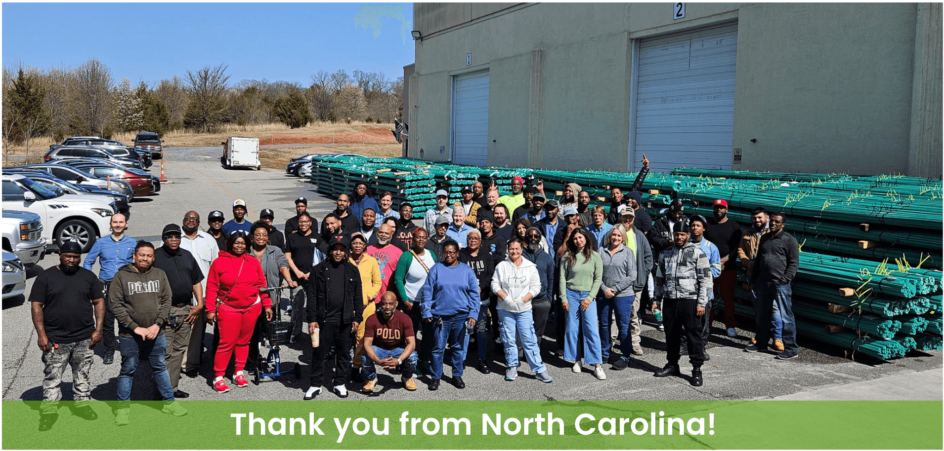 Employees posing in front of the Mateenbar factory in front of Greenbar2X fiberglass rebar.